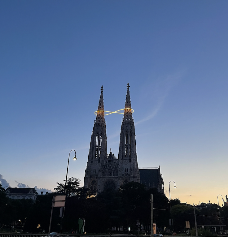 Votivkirche in Vienna, Austria, with an illuminated infinity sign on it.